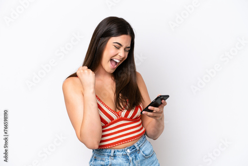 Young Brazilian woman isolated on white background with phone in victory position