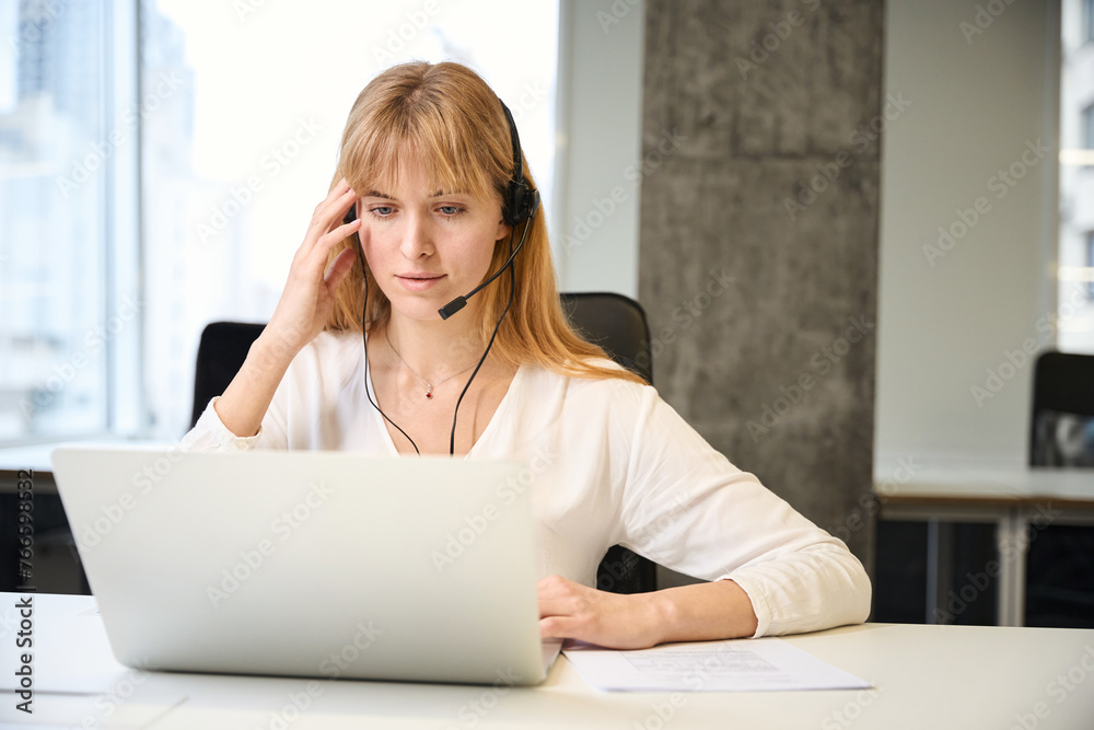 Busy woman in headset communicating with client in online sales Busy woman in headset communicating with client in online sales