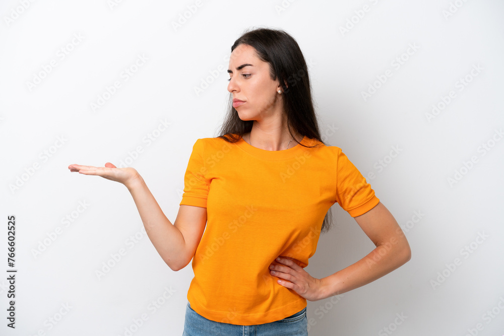 Young caucasian woman isolated on white background holding copyspace with doubts Young caucasian woman isolated on white background holding copyspace with doubts