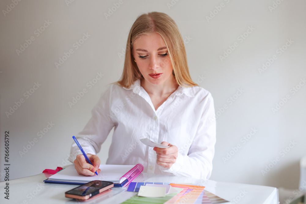 girl designer works in the office at her desk girl designer works in the office at her desk