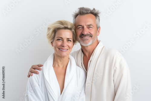 Middle aged couple over isolated white background in a bathrobe