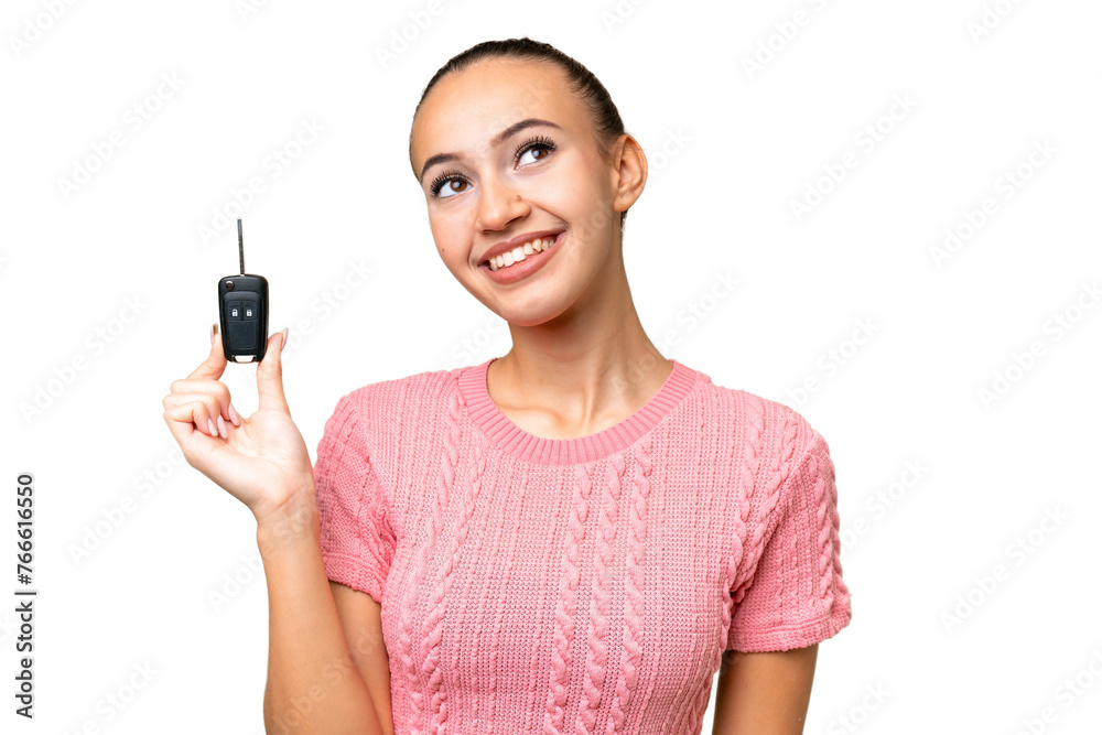 Young Arab woman holding car keys over isolated background looking up while smiling Young Arab woman holding car keys over isolated background looking up while smiling