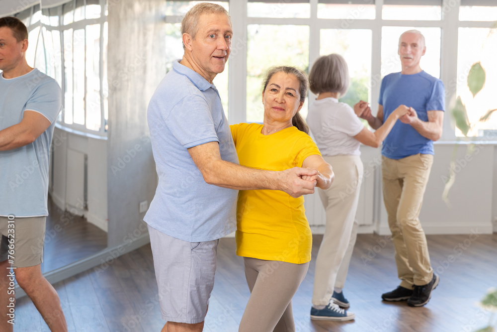Fototapeta premium Elderly man and elderly woman dance ballroom dance waltz in studio