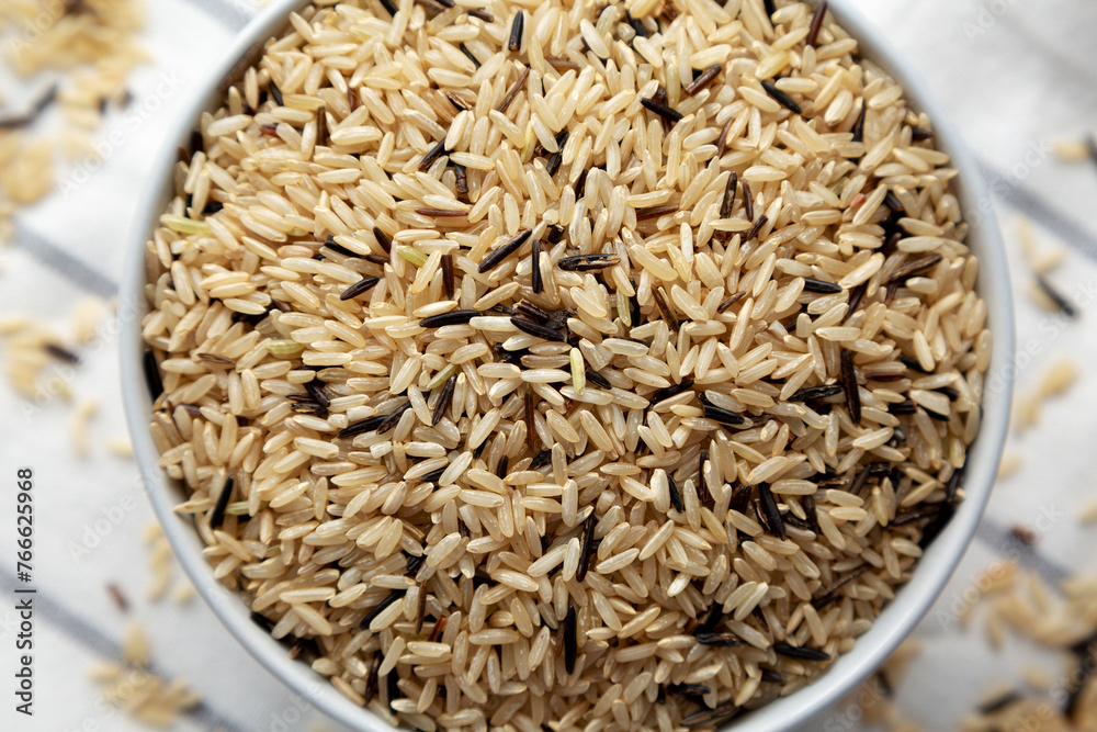 Raw Organic Wild Rice in a Bowl on a white wooden background, top view. Raw Organic Wild Rice in a Bowl on a white wooden background, top view.