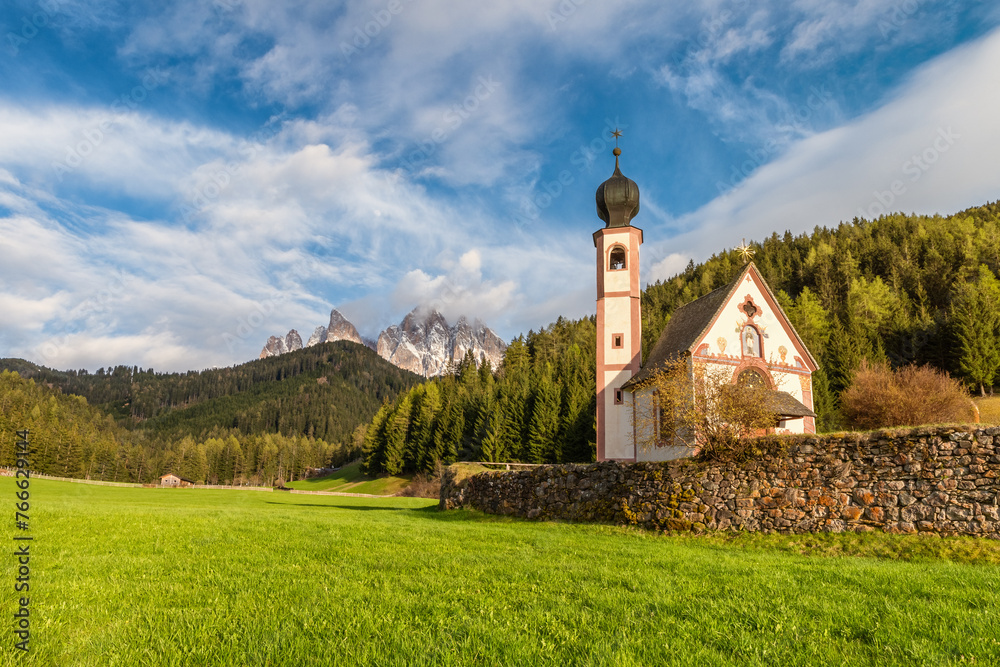 Church of St. John against the Geisler mountains in Santa Magdalena village, Val Di Funes in Dolomites mountains, South Tyrol, Italy. Italian Alps in springtime. Popular travel destination