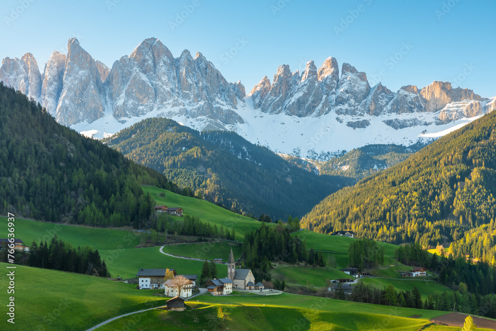 Morning landscape with Santa Magdalena village against the Geisler mountains covered with snow at sunrise, Val Di Funes valley in Dolomites mountains, South Tyrol, Italy. Italian Alps in springtime