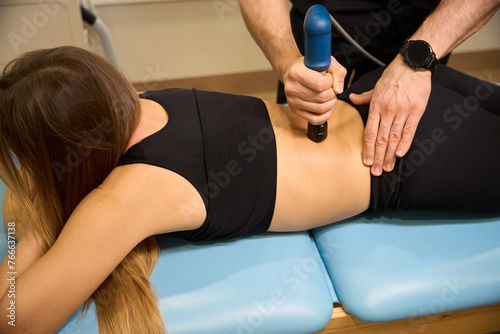 Female patient undergoing a physiotherapeutic procedure in a wellness center