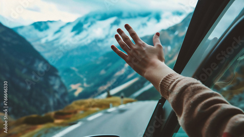 Hands of a woman in the car on the background of mountains
