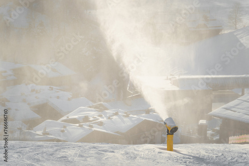 Schneekanonen beschneien die Piste mit Kunstschnee für Skifahrer und Snowboarder bei Frost im Winter.