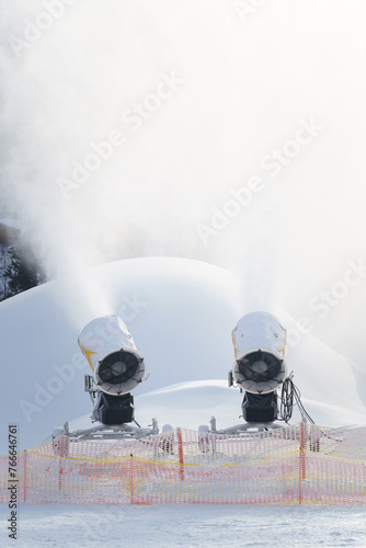 Schneekanonen beschneien die Piste mit Kunstschnee für Skifahrer und Snowboarder bei Frost im Winter. photo