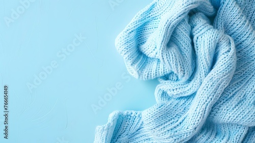 Soft, chunky blue knitted blanket on a blue background. photo