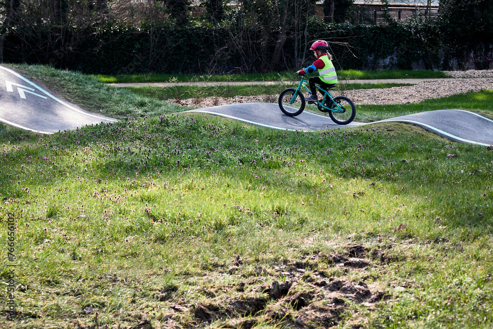 Fototapeta premium Petite fille faisant du vélo dans un Pump track