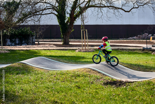 Petite fille faisant du vélo dans un Pump track