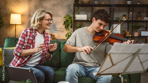 Young man learn how to play violin under instruction mature professor