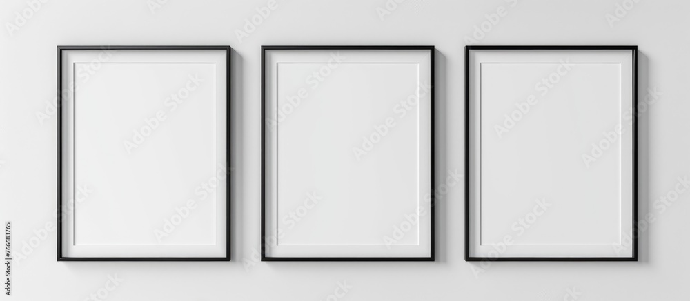 Mockup of white posters with black frames on a plain background.