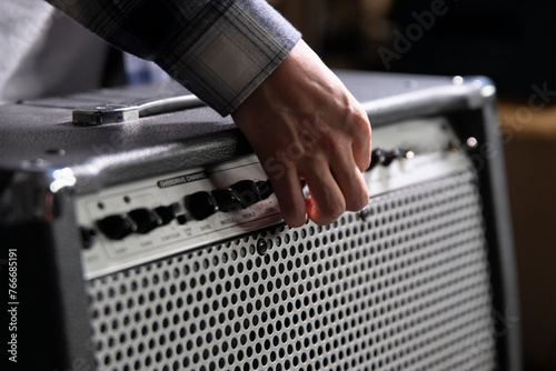 Canvastavla Guitarist Fine-Tunes Amplifier Settings Before a Performance in a Backstage Area