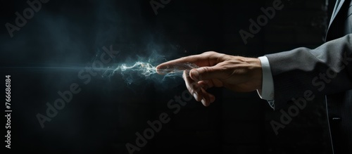 Close up of businessman hand touching smoke on dark background with copy space