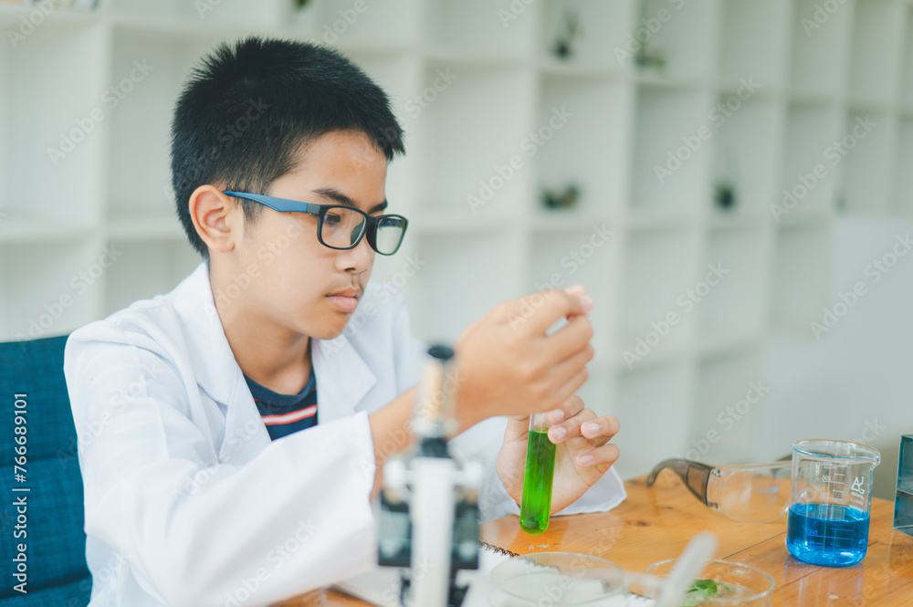 Asian male science students looking through a microscope and tests of plants in the classroom. Learning about scientific experiments on plant species. Asian male science students looking through a microscope and tests of plants in the classroom. Learning about scientific experiments on plant species.