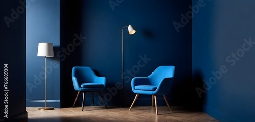 two blue chairs and a lamp in a dark room