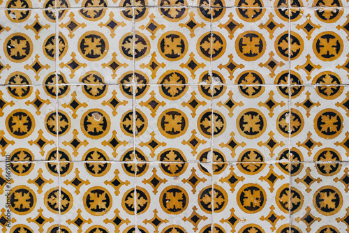 Traditional Portuguese ceramic azulejos tiles, retro pattern. Beautiful shabby yellow, brown facade, wall banner. Old Lisbon building, Portugal decorative background with geometric floral ornaments.