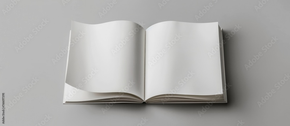 Design concept showing a white notebook from a top view, with blank pages opened, turned, and flipped on a gray background for a mockup. The image is a real photograph, not a . - obrazy, fototapety, plakaty 