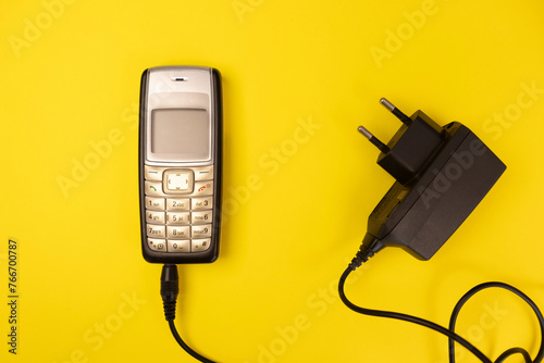 Vintage cellphone on a yellow background photo