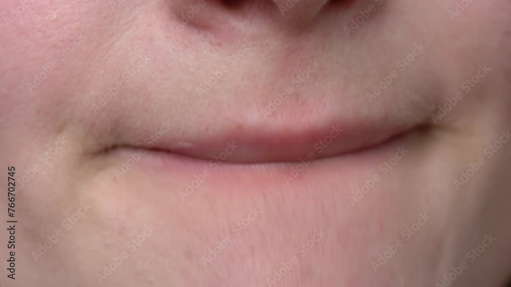 Model applying moisturizer to her plump lips using one finger with long manicured nails before applying lipstick. Extreme close-up natural red lips, highlighting application process of cosmetics Model applying moisturizer to her plump lips using one finger with long manicured nails before applying lipstick. Extreme close-up natural red lips, highlighting application process of cosmetics