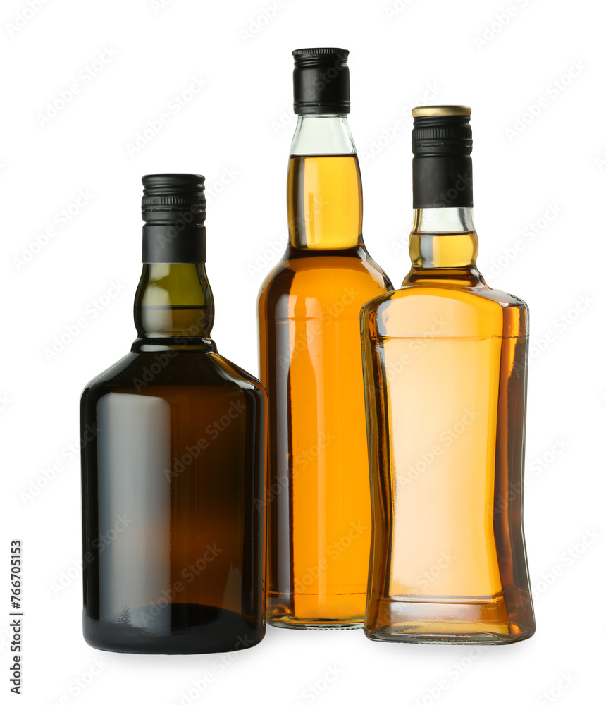 Different sorts of whiskey in glass bottles isolated on white Different sorts of whiskey in glass bottles isolated on white