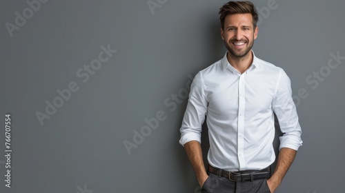 Image of happy brunette man wearing formal clothes smiling at camera with hands in pockets isolated over gray background photo