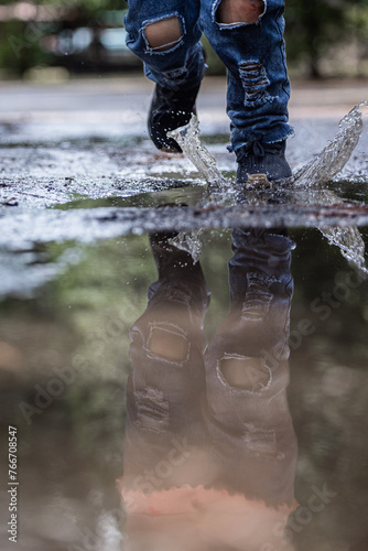 A person is walking in the rain with their feet in the water