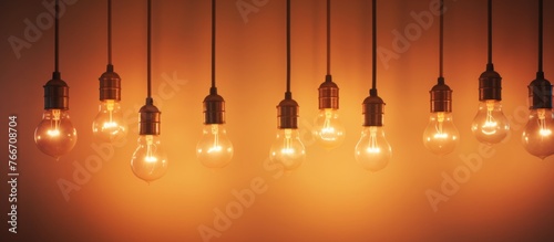 A row of amber and orange tinted light bulbs, filled with gas to produce heat, hang from the wooden ceiling in a circle pattern