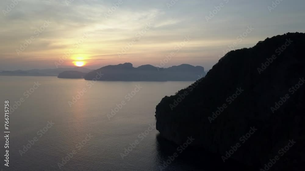 Aerial Backward Shot Of Silhouette Of Rock Formations In Rippled Ocean Under Dramatic Clouds At Sunset - Palawan, Philippines Aerial Backward Shot Of Silhouette Of Rock Formations In Rippled Ocean Under Dramatic Clouds At Sunset - Palawan, Philippines