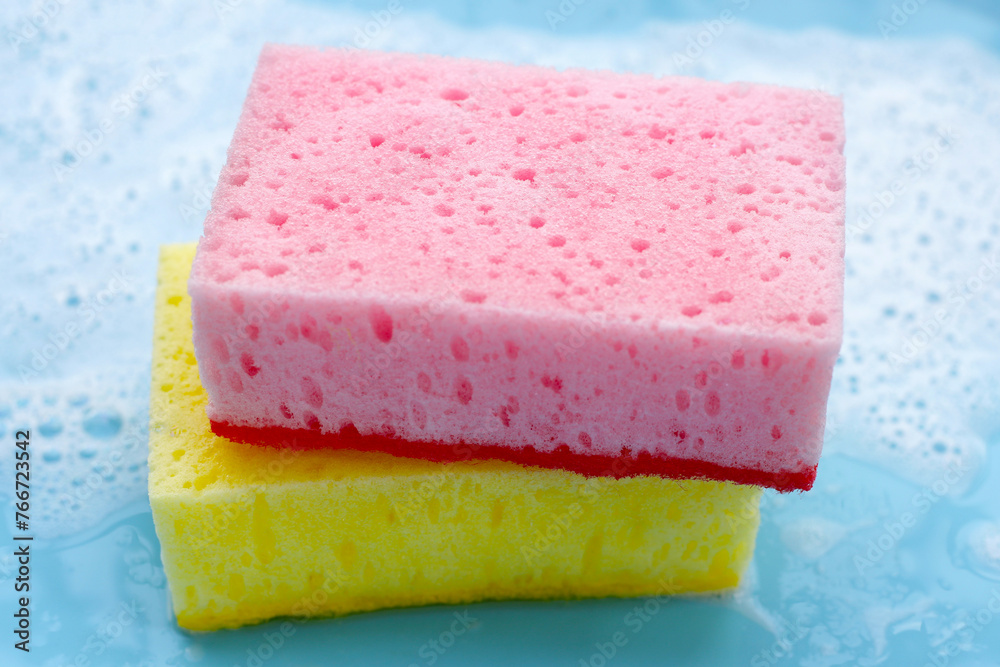 Cleaning sponge in foam of dishwashing liquid. Washing dishes concept Cleaning sponge in foam of dishwashing liquid. Washing dishes concept