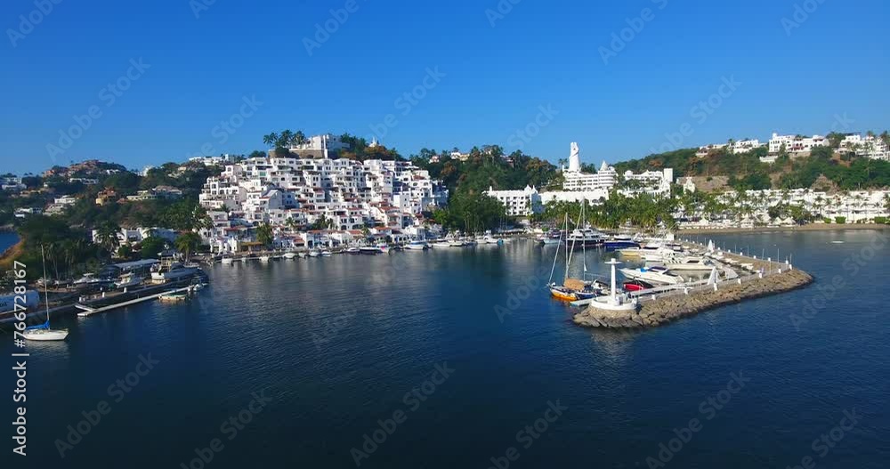 Low shot sliding along the entrance to a calm marina in a beautiful tropical town along a gorgeous coastal island Low shot sliding along the entrance to a calm marina in a beautiful tropical town along a gorgeous coastal island