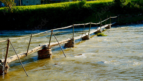 Wood water wheel Baler Machine in Agriculture Farm impeller lifted pumping water in river. Wooden Water Baler Machine green garden Farm blades by windy natural. Sustainable Resources Environment