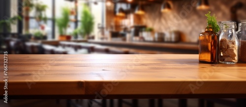 A lightfilled restaurant with hardwood flooring and a wooden table showcasing bottles on top. The wood stain on the plank gives a cozy and chic vibe  complemented by a plant nearby