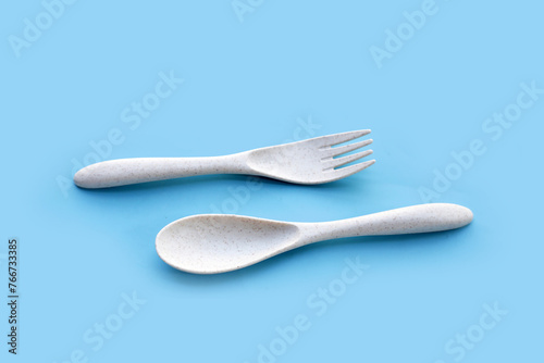 Spoon and fork on blue background.