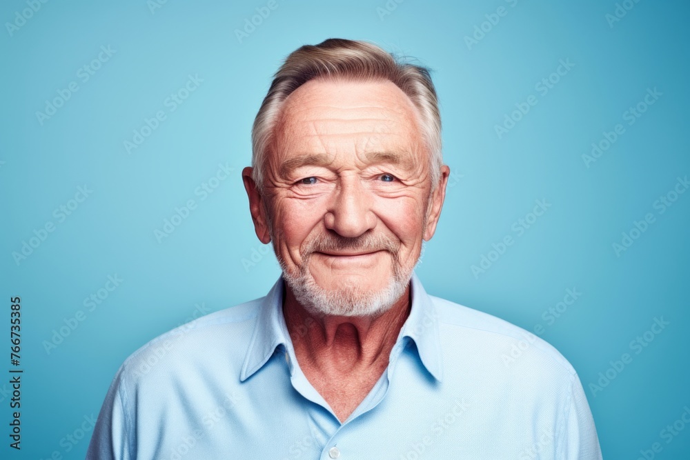 Portrait of a smiling senior man looking at camera against blue background Portrait of a smiling senior man looking at camera against blue background