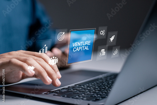 Venture capital funding concept. Mutual funds, financial institutions and fundraising. Businessman use laptop with venture capital icon on virtual screen. photo