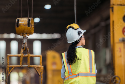 Portrait of railway technician worker in safety vest and helmet working at train repair station