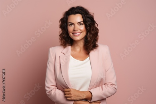 Portrait of happy young business woman in pink suit on pink background