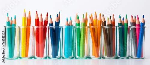 A row of various colored pencils are neatly arranged on a table, showcasing shades like electric blue and magenta. These office supplies are essential for art and fashion design