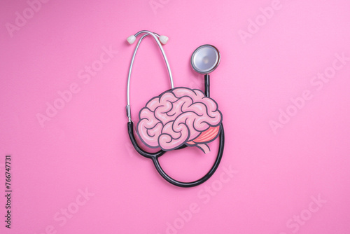 Stethoscope with human brain cutout paper. Health or pathological condition of human brain, diagnosing diseases of nervous system. photo
