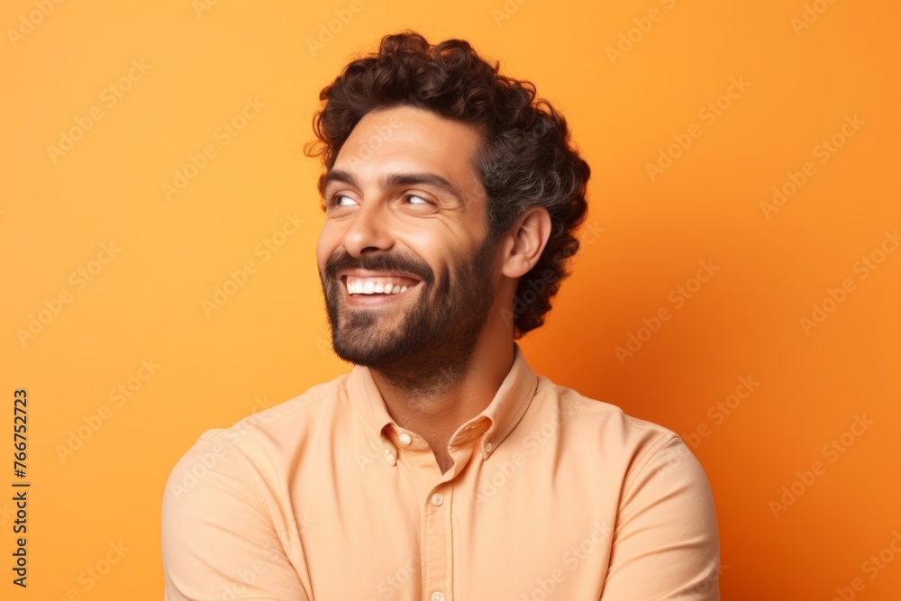Portrait of happy young man laughing and looking up over orange background Portrait of happy young man laughing and looking up over orange background