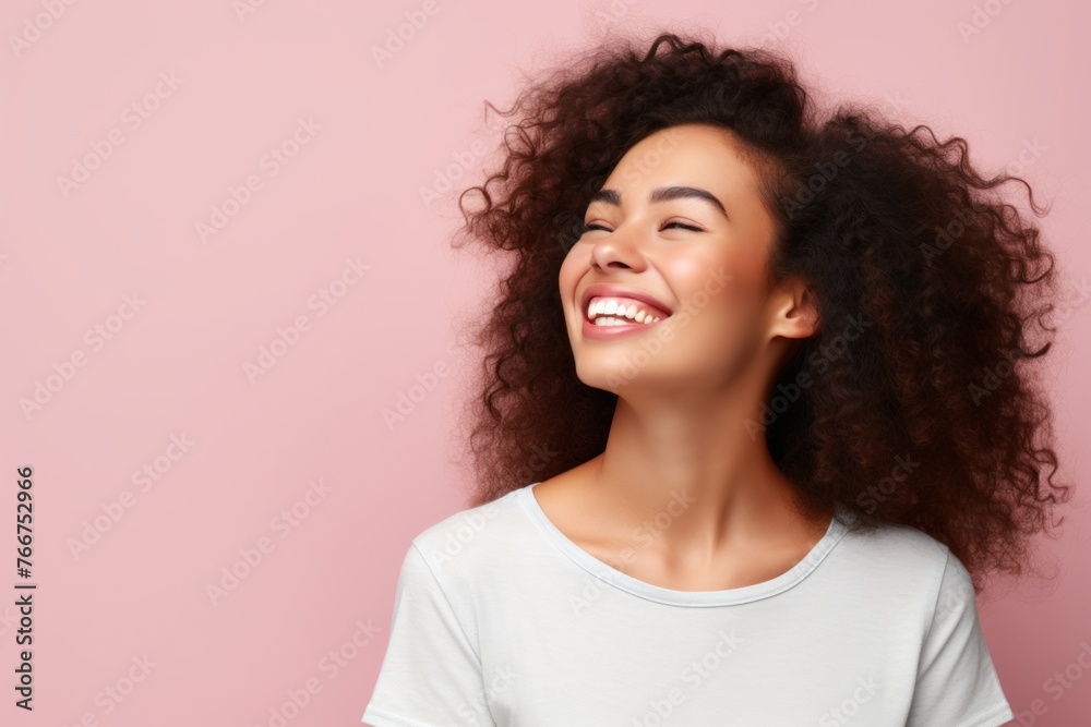 Happy african american young woman with curly hair on pink background Happy african american young woman with curly hair on pink background
