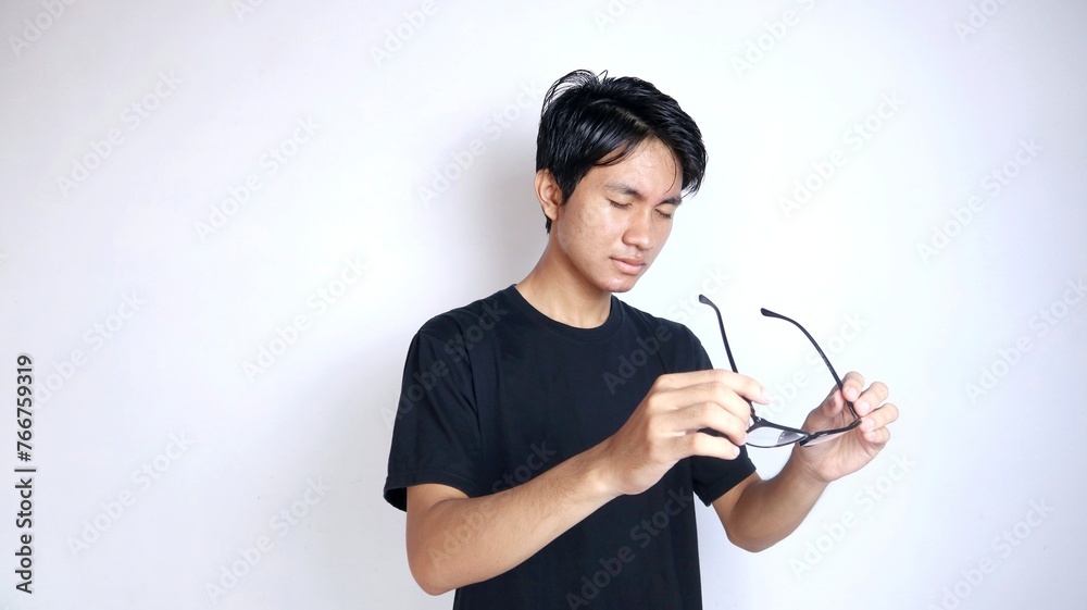 Young Asian man happily gesturing looking and using glasses Young Asian man happily gesturing looking and using glasses
