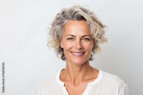 Portrait of a beautiful mature woman smiling at the camera on a white background