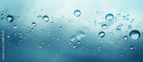 Water bubbles float in liquid on an electric blue background, creating a mesmerizing display of aqua circles in the sky