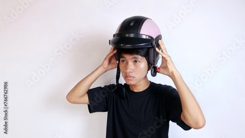 Young Asian man gesturing using a helmet