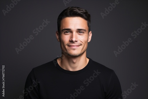 Portrait of a handsome young man in black t-shirt over dark background.